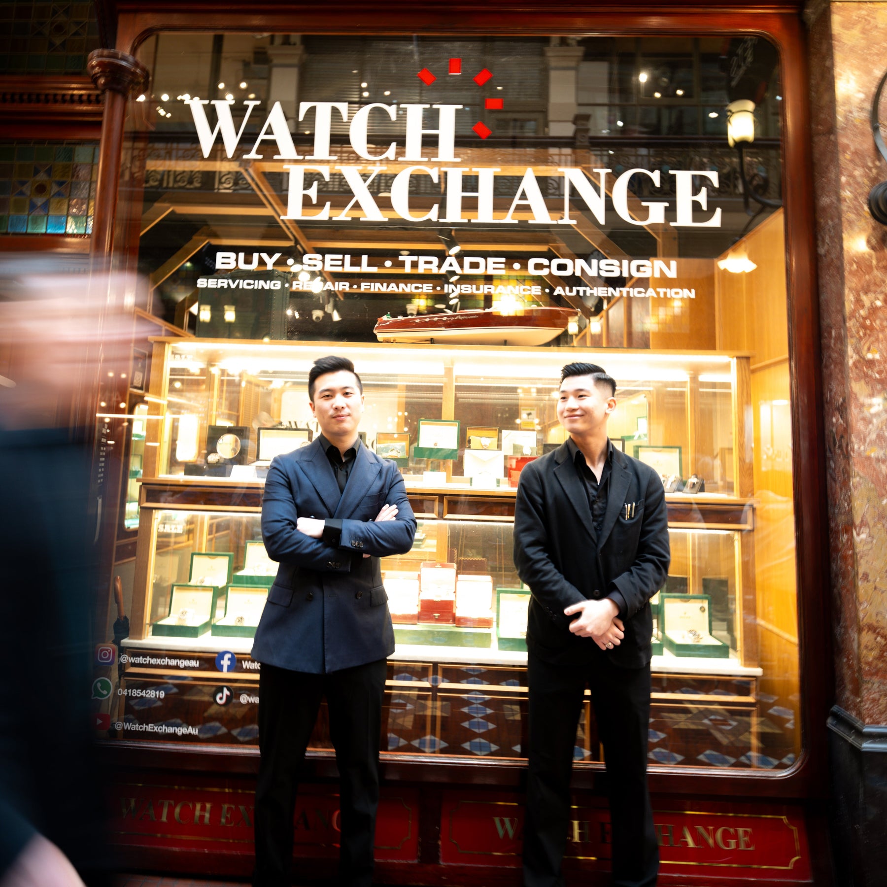 The two Watch Exchange team members outside their illuminated Strand Arcade storefront, beneath the Watch Exchange signage
